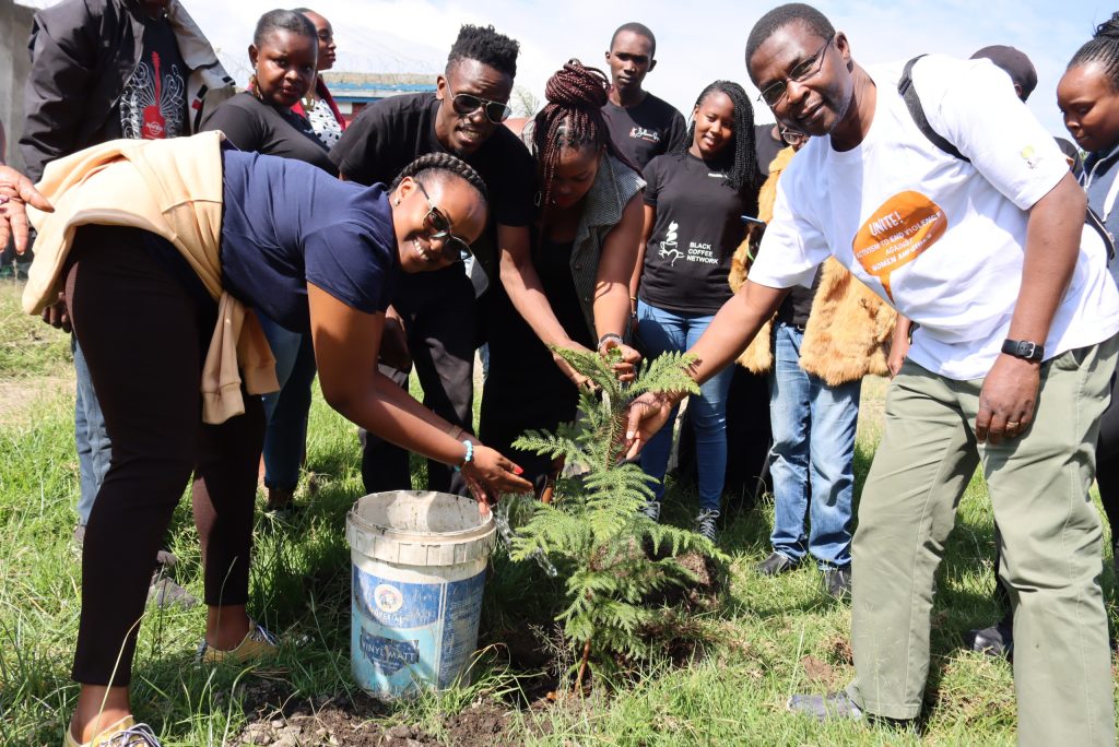 Make Way Country Coordinators Samuel Obara, Kenya (right), Ariane Dusenge, Rwanda (left) and youth from BCN planting a tree outside Hilton Social Hall in June.